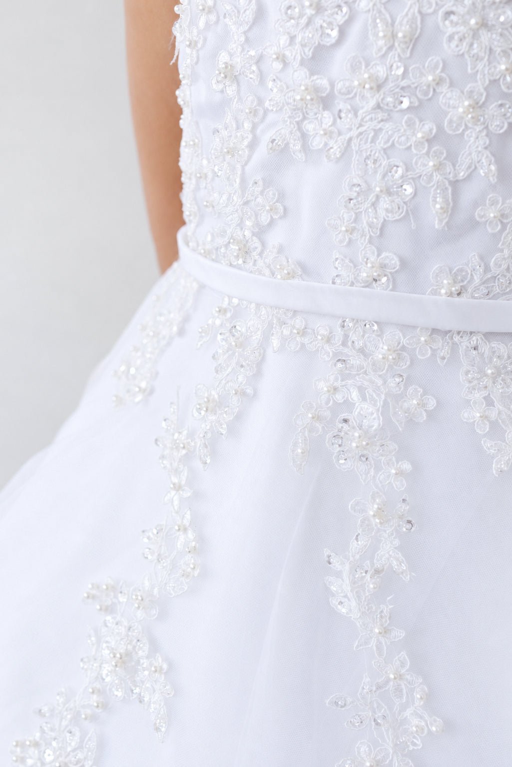 Beads pick out flower centers on this white flower girl dress.