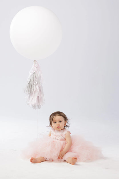 Soft tulle tiers are visible on the blush flower girl dress.