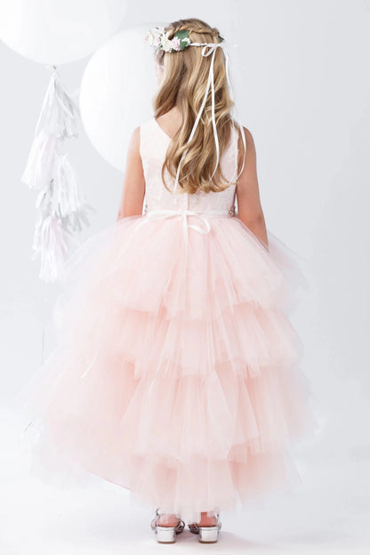 A view of a tiered tulle back skirt on the blush flower girl dress.