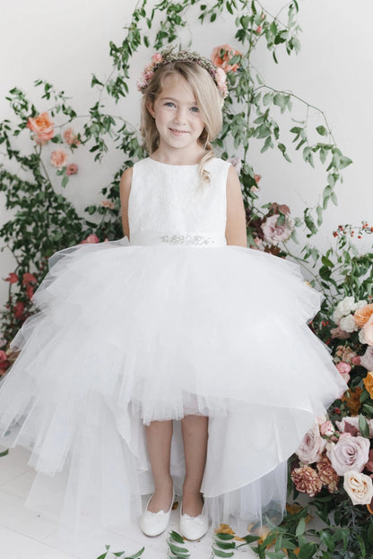 White flower girl dress with a tiered high-low skirt.