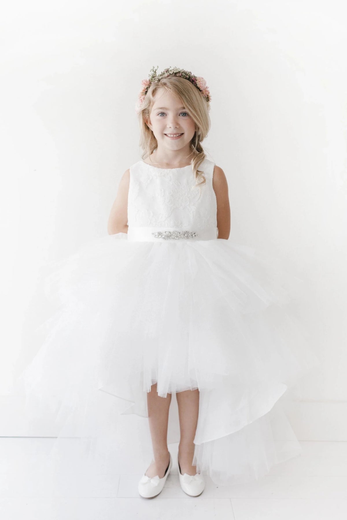 Defined by a beaded waist accent, this white flower girl dress.