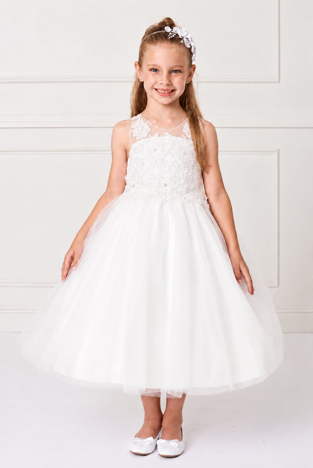 Lace climbs the sheer straps of this off-white flower girl dress.