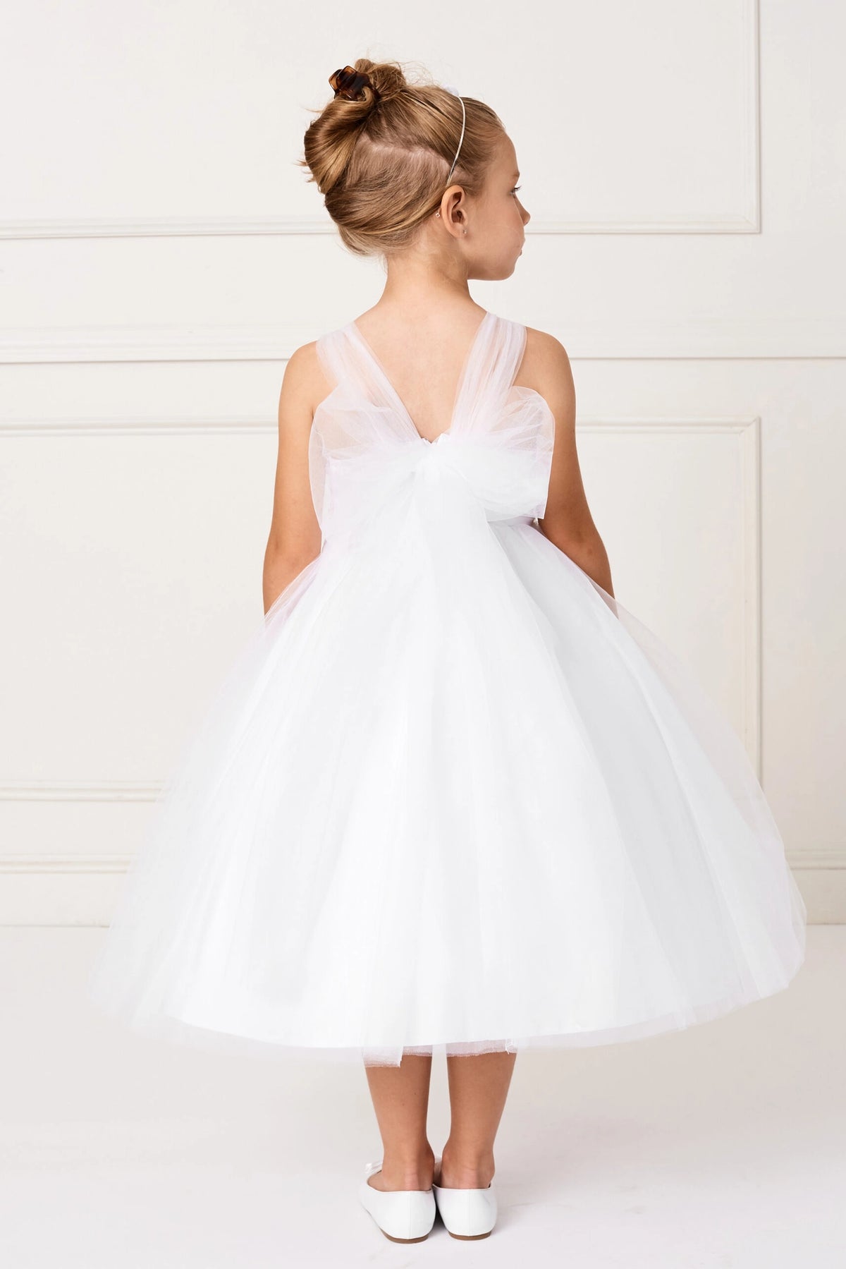 Large tulle bow shown on the white flower girl dress.