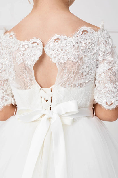 A keyhole interrupts the lace back of this off-white flower girl dress.