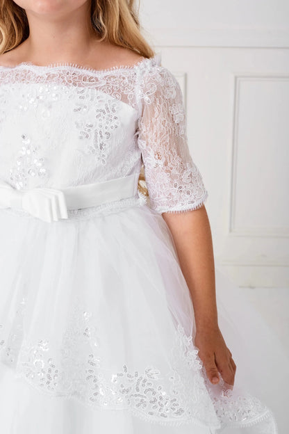 A flat bow sits at the front waist of the white flower girl dress.