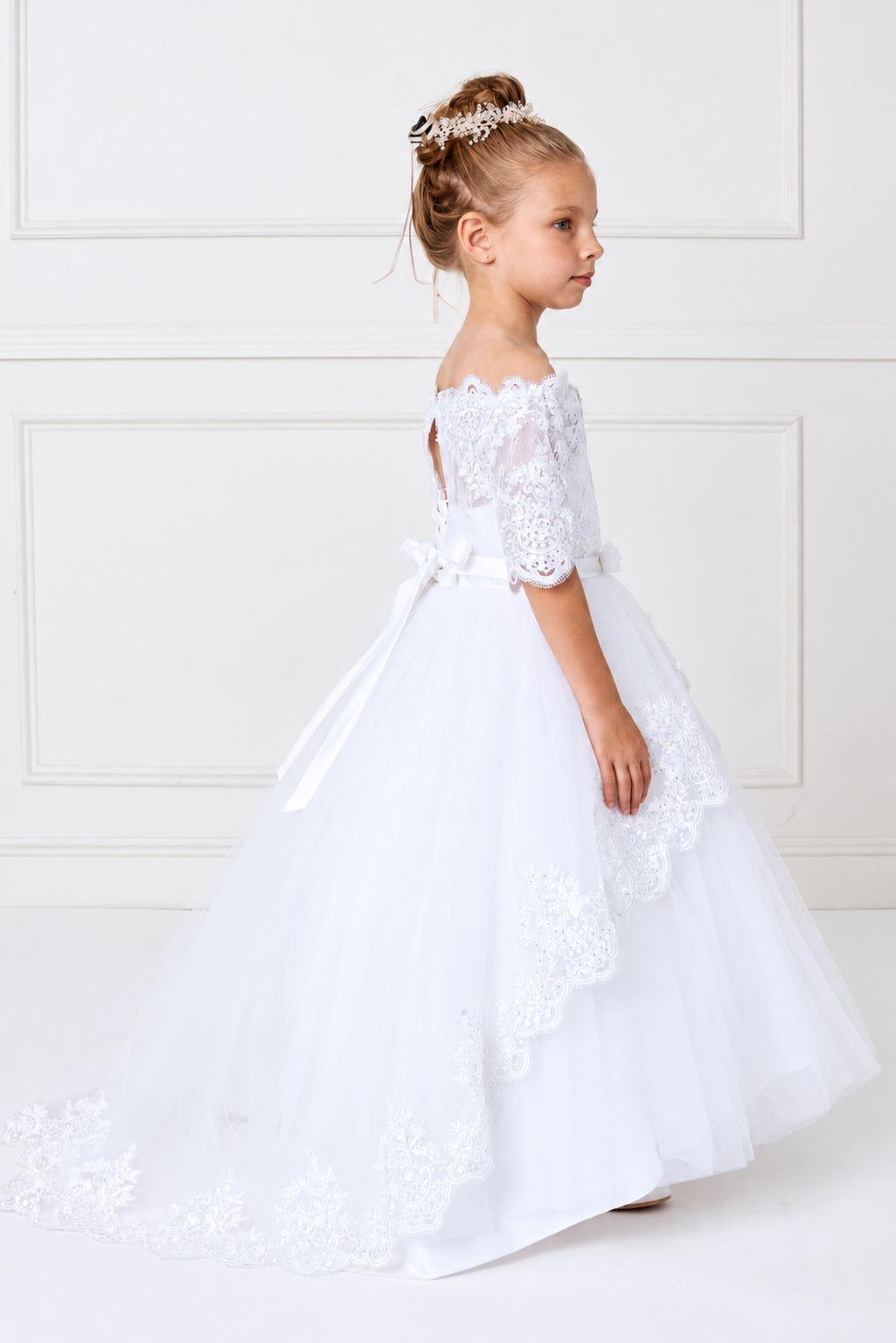 Lace drapes in scalloped tiers on this white flower girl dress.