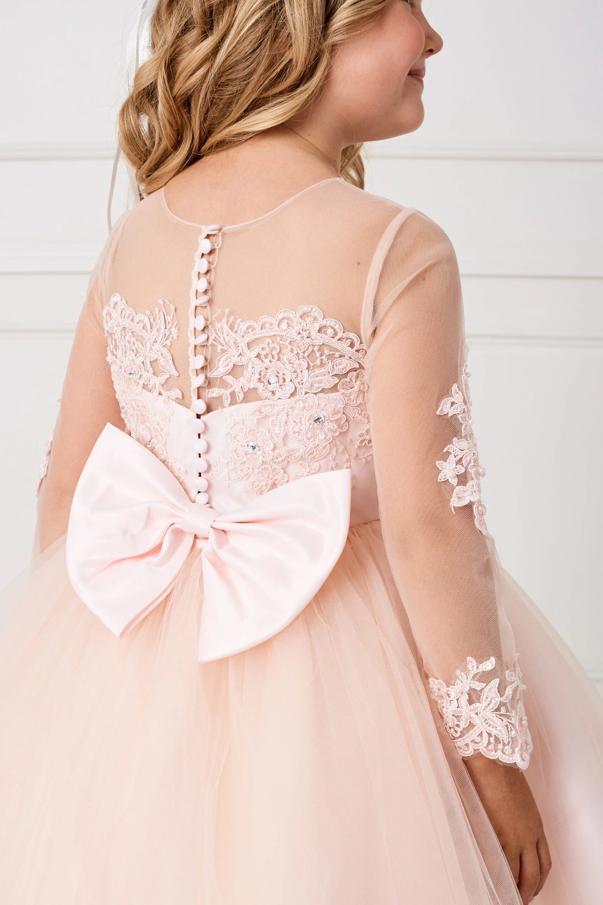 On the Blush kids pageant dress, the detailing includes a large satin bow at the back waist.