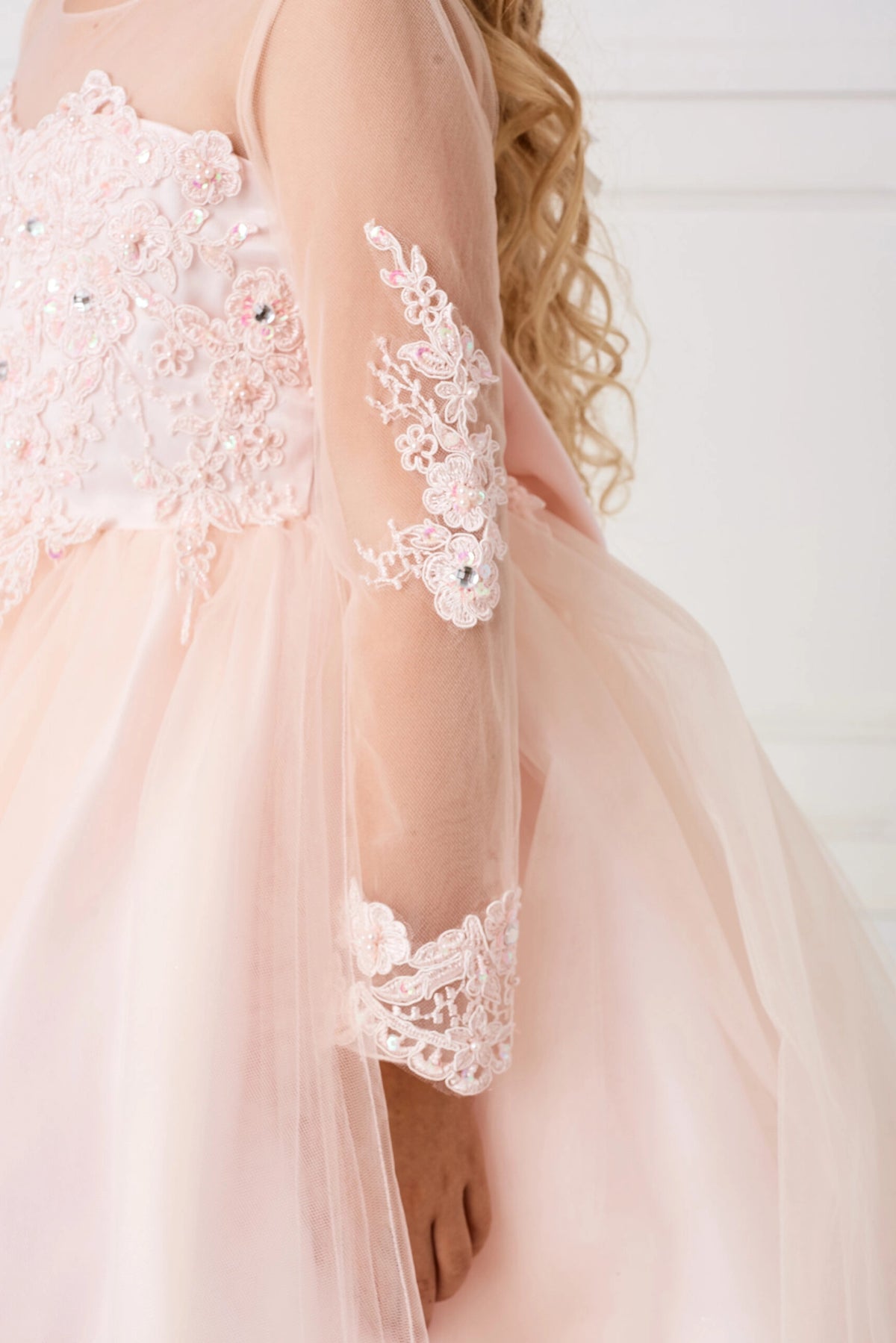 Another view of the Blush kids pageant dress shows lace applique on a sheer sleeve.
