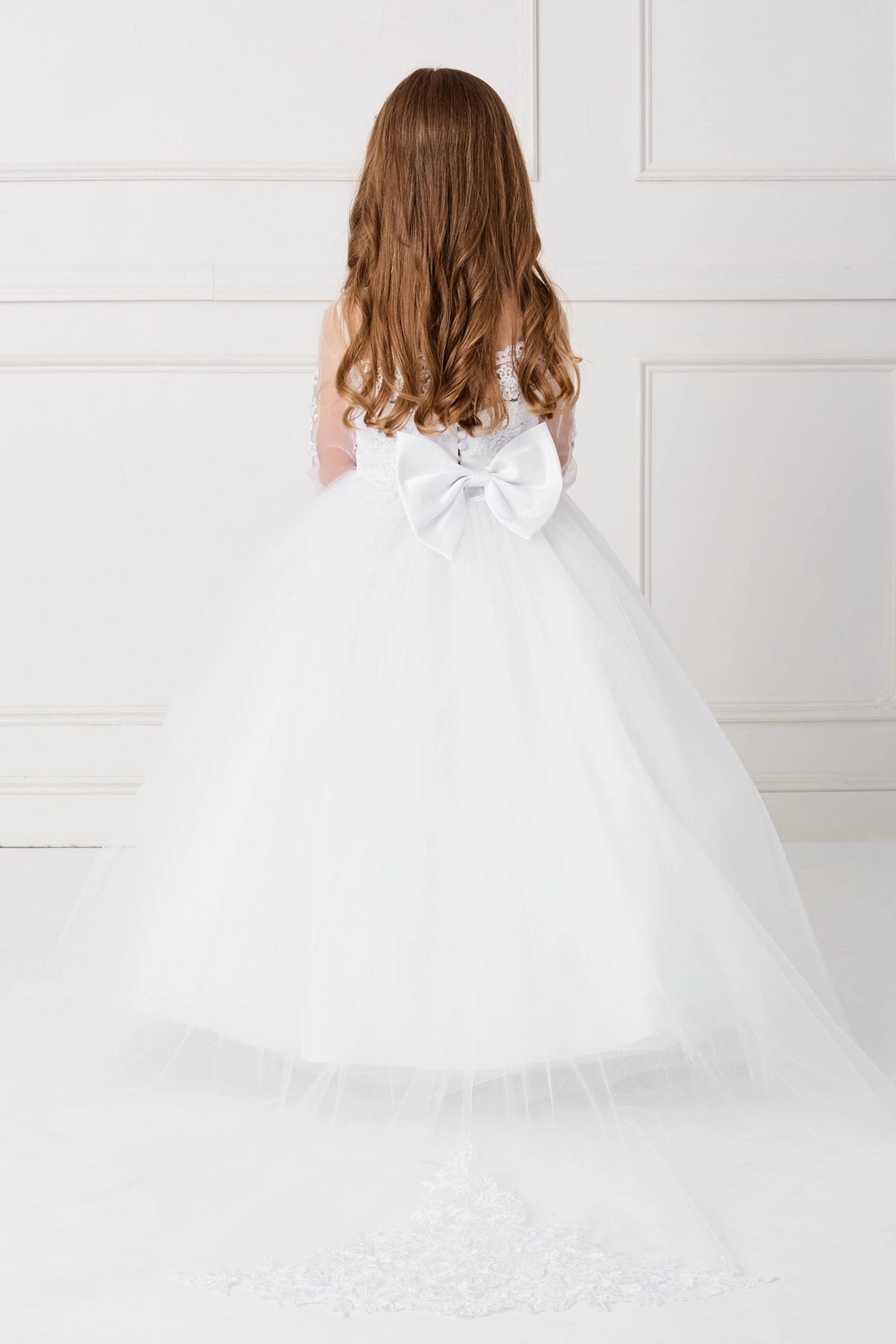 Seen from behind, this White kids pageant dress displays the rear bodice and layered skirt.
