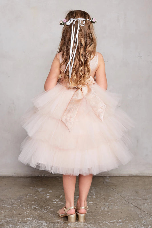 Featuring a large satin back bow, a rose gold flower girl dress.