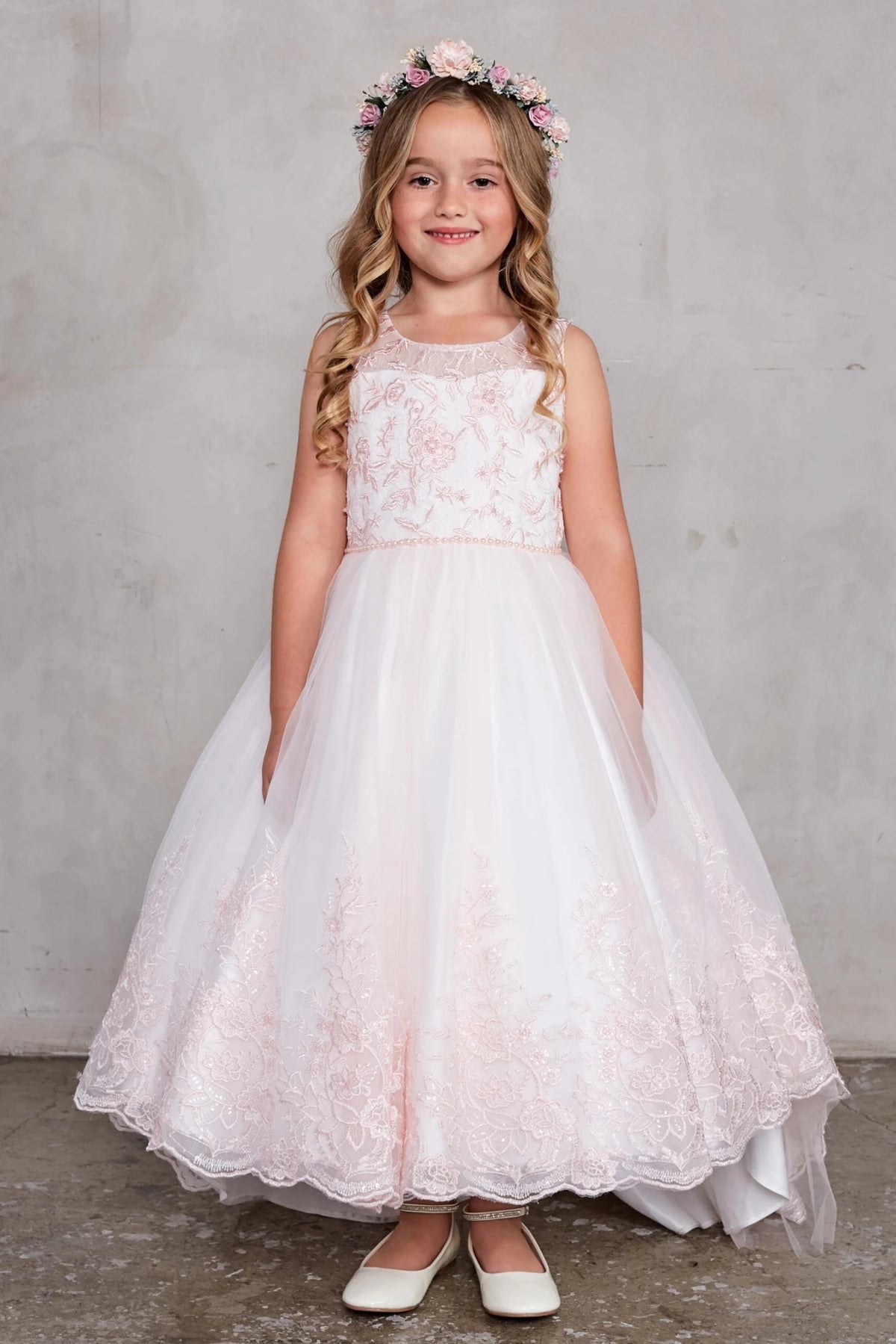 Lace-trimmed high-low skirt: detail of the blush flower girl dress.