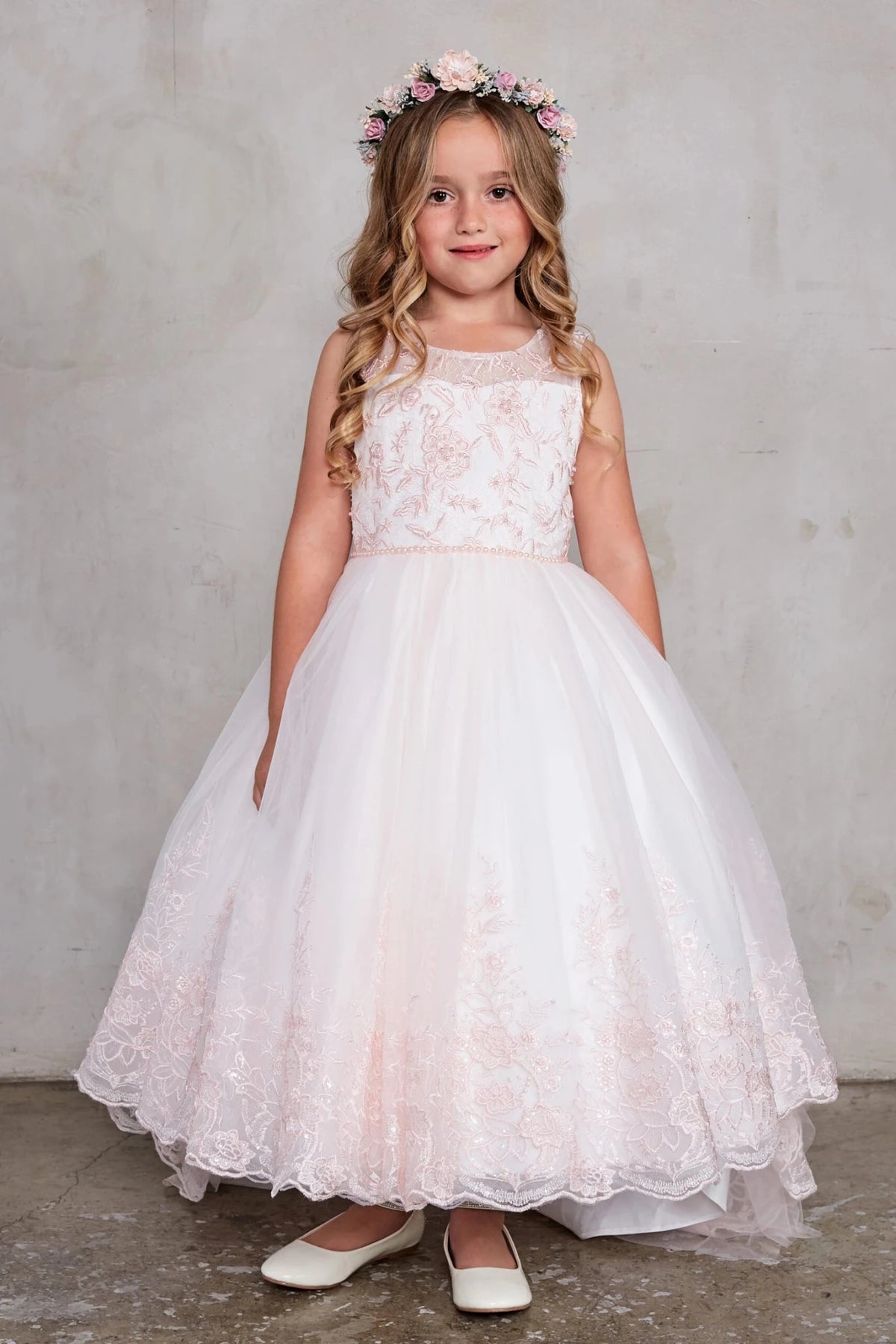 A view of an embroidered hem border on the blush flower girl dress.