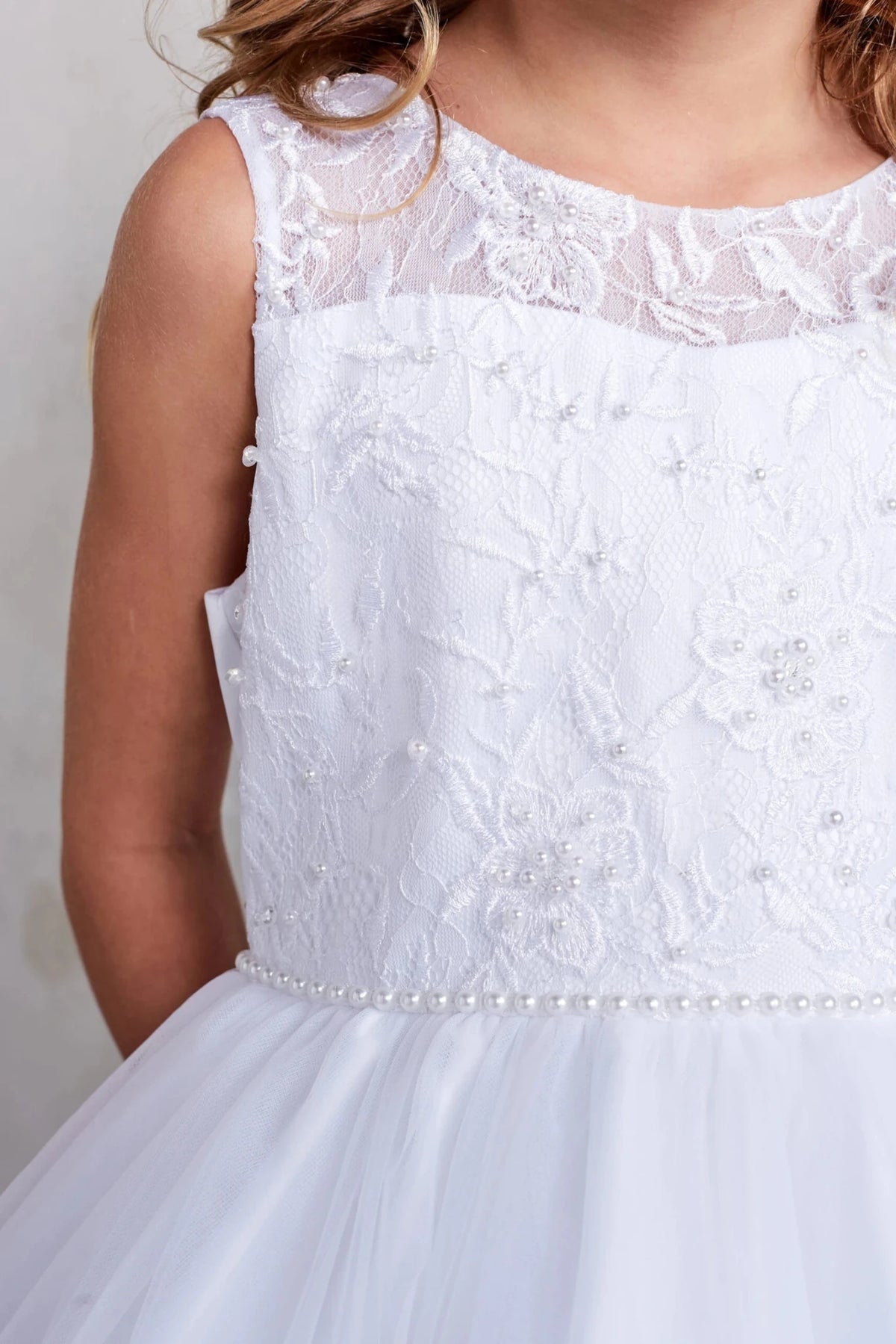 Defined by a pearl waistband, this white flower girl dress.