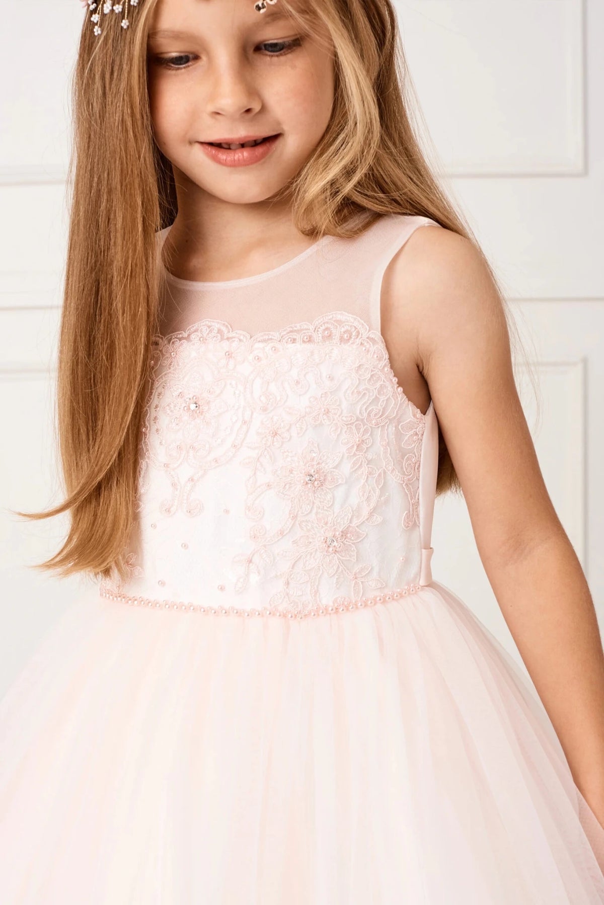 Across the chest, blush flower girl dress lace forms a scalloped border.