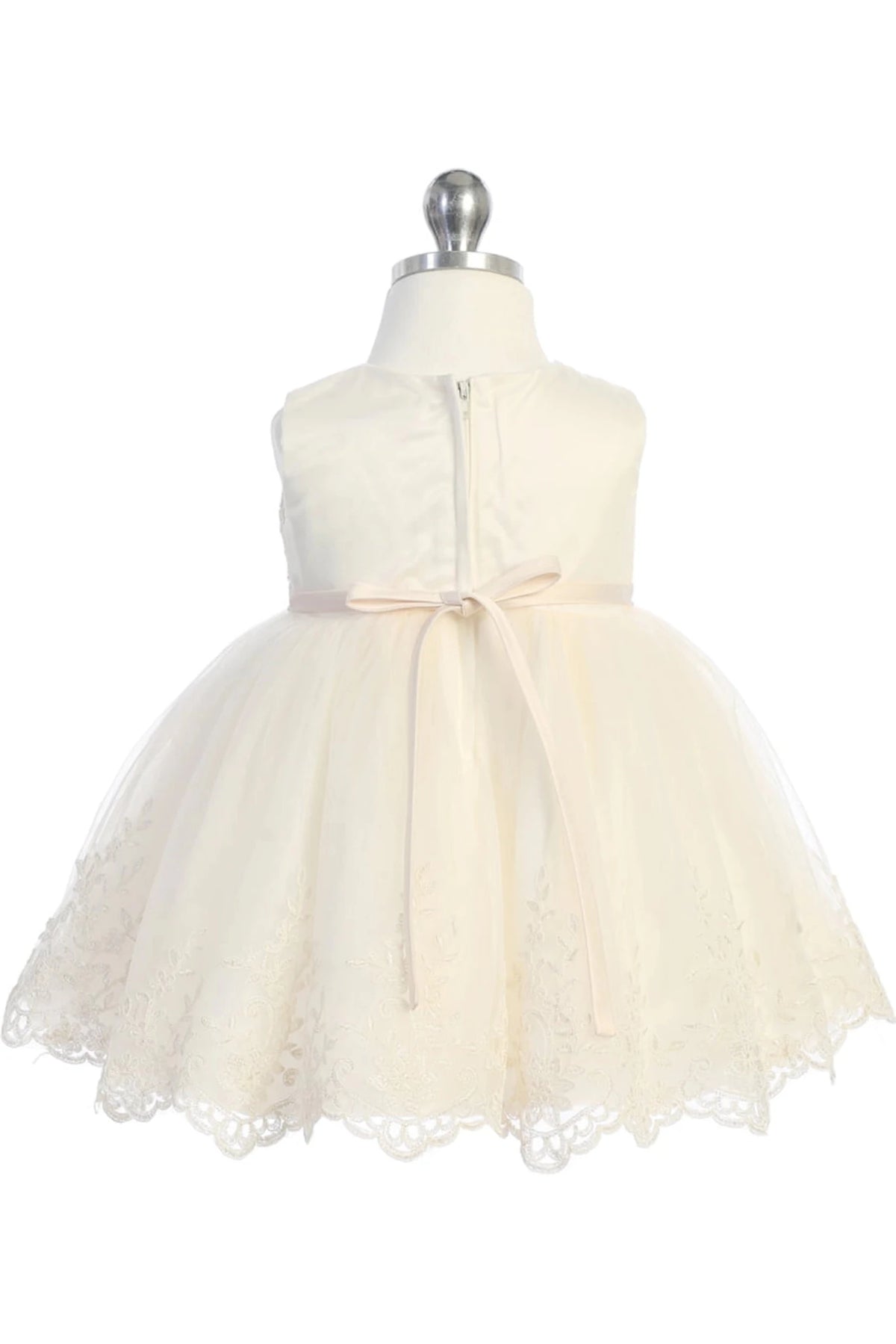 Ribbon loops form a small bow on the champagne flower girl dress's back.