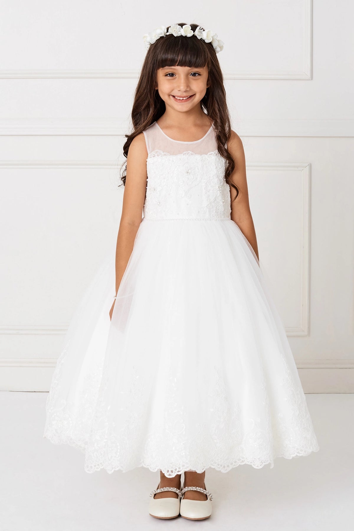 Rounded sheer yoke above the off-white flower girl dress's scalloped bodice.