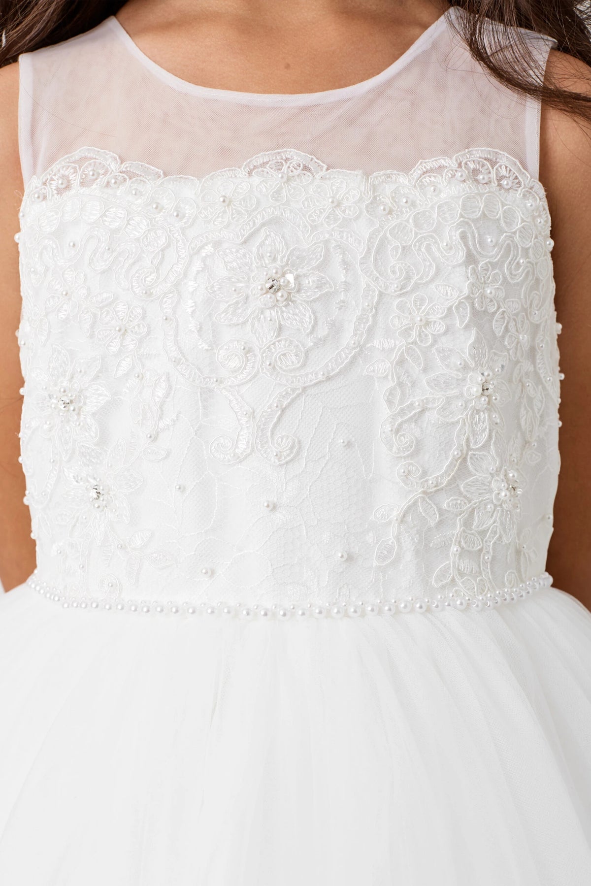 Large embroidered blossoms cover the off-white flower girl dress's bodice.