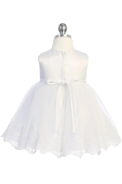 Narrow ribbon ties finish the back of an off-white flower girl dress.