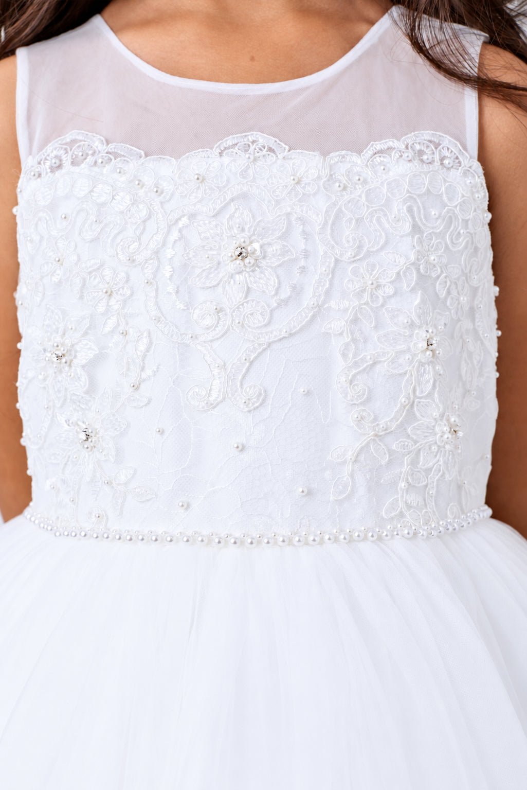 White flower girl dress bodice covered in large embroidered flowers.