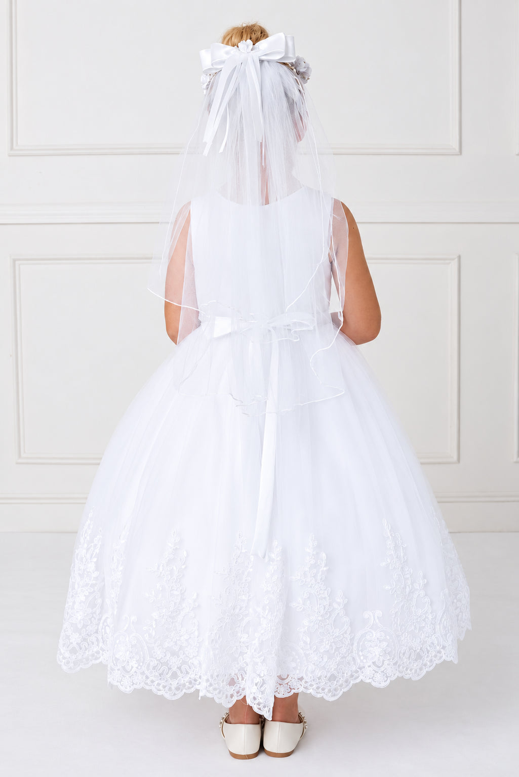 Seen from behind, the white flower girl dress has a plain fitted back.