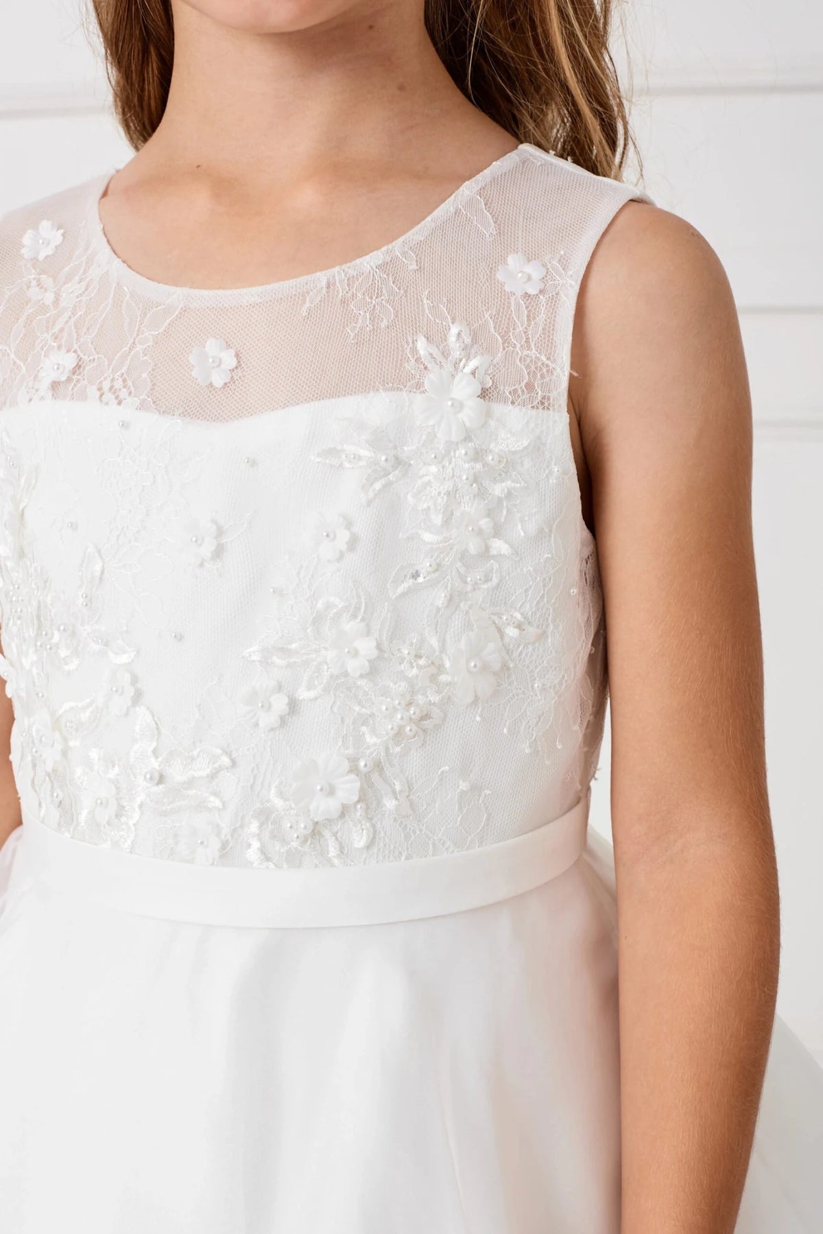 Shown here, an off-white flower girl dress with a sheer embroidered neckline.