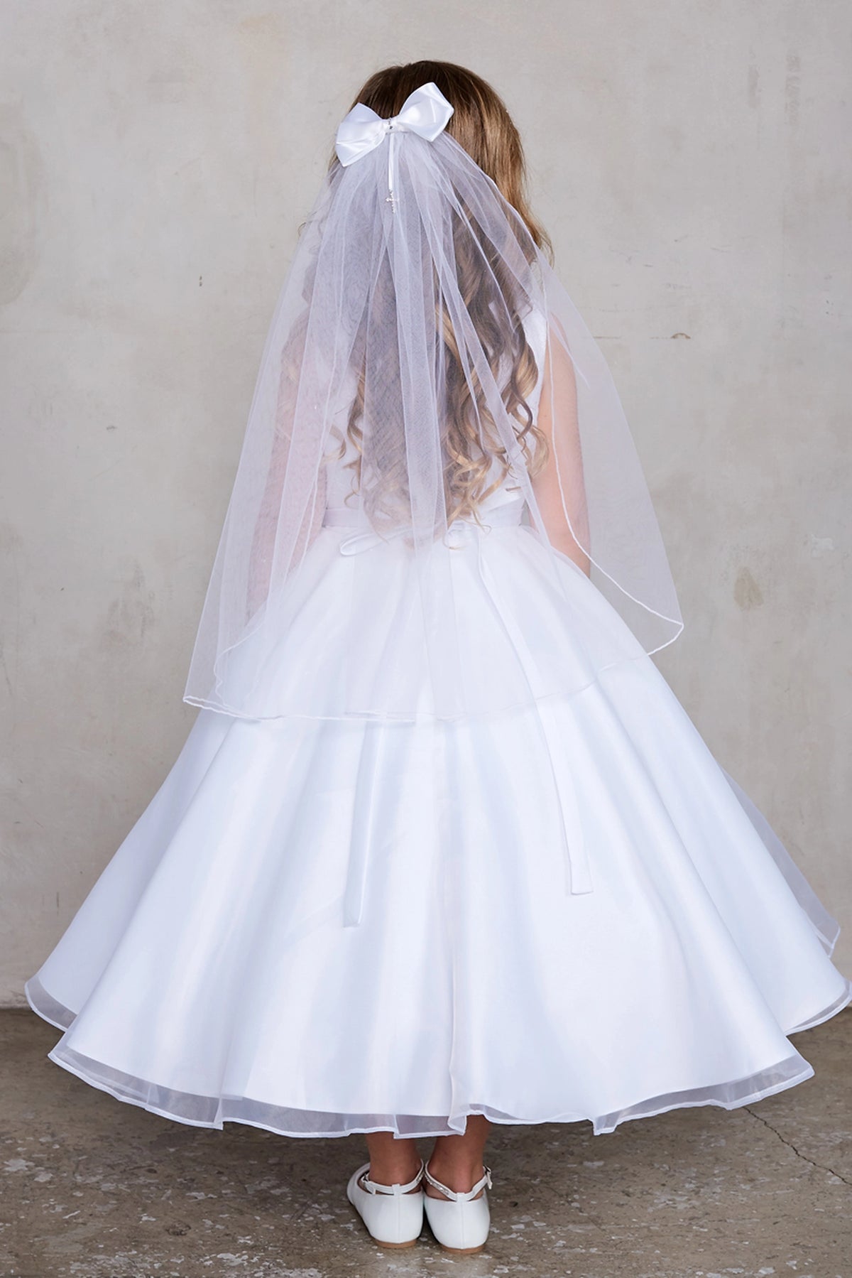 Wide back skirt on a white flower girl dress.