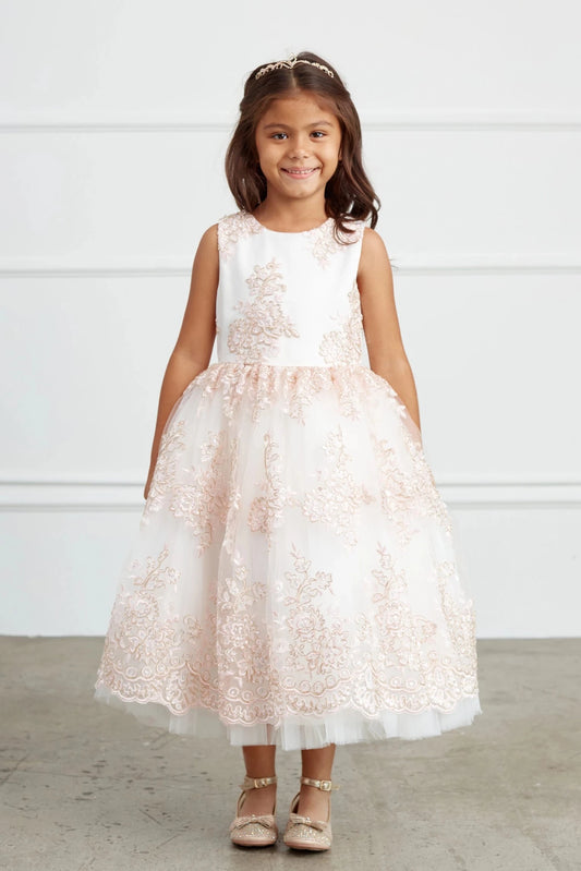 The blush flower girl dress features metallic floral skirt embroidery.