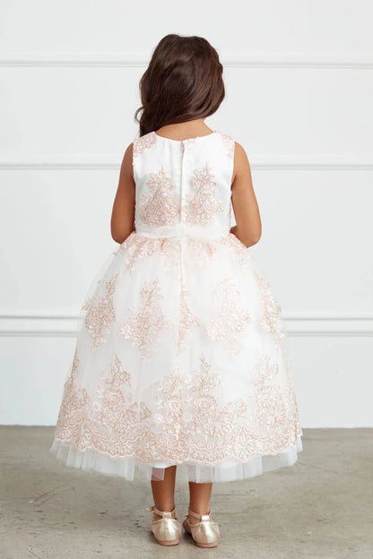 This blush flower girl dress displays sheer floral back.