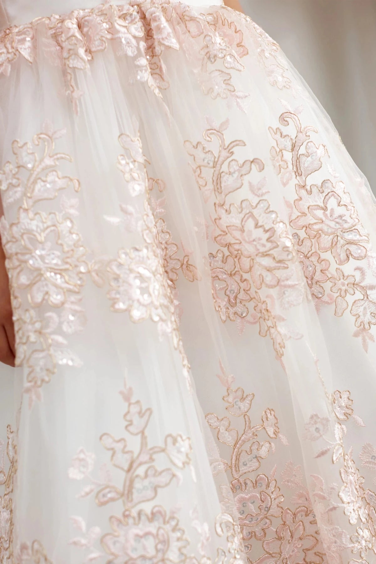 Gold lace skirt motifs: detail of the blush flower girl dress.