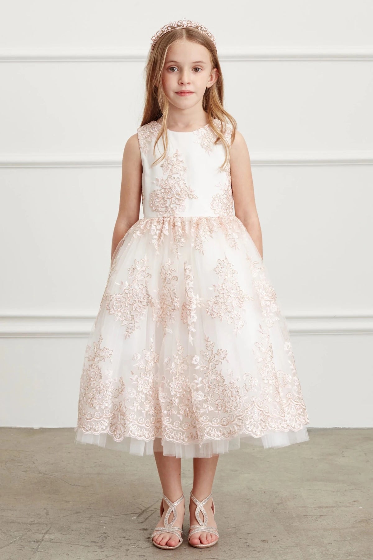 Shown here, a blush flower girl dress with a scalloped overlay hem.