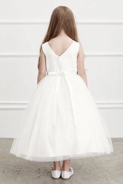 A low V shapes the plain back of an off-white flower girl dress.