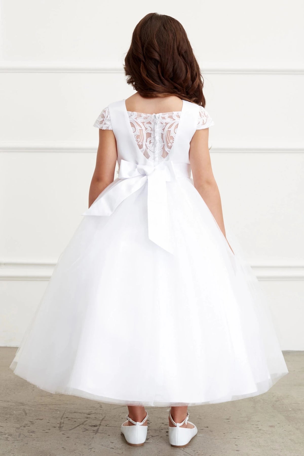 Focus on sheer floral back of the white flower girl dress.
