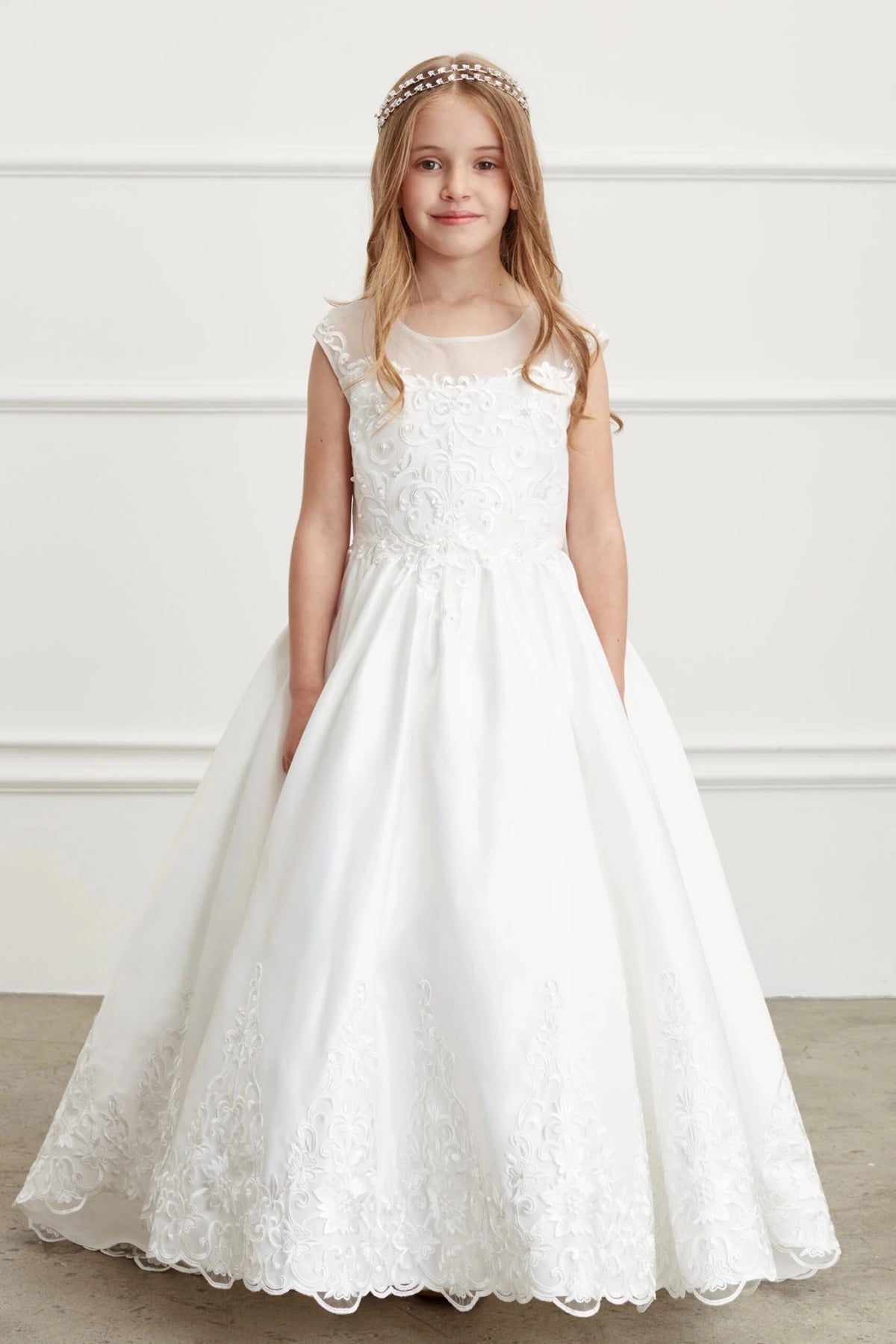 Rosette embroidery fills the bodice of this off-white flower girl dress.