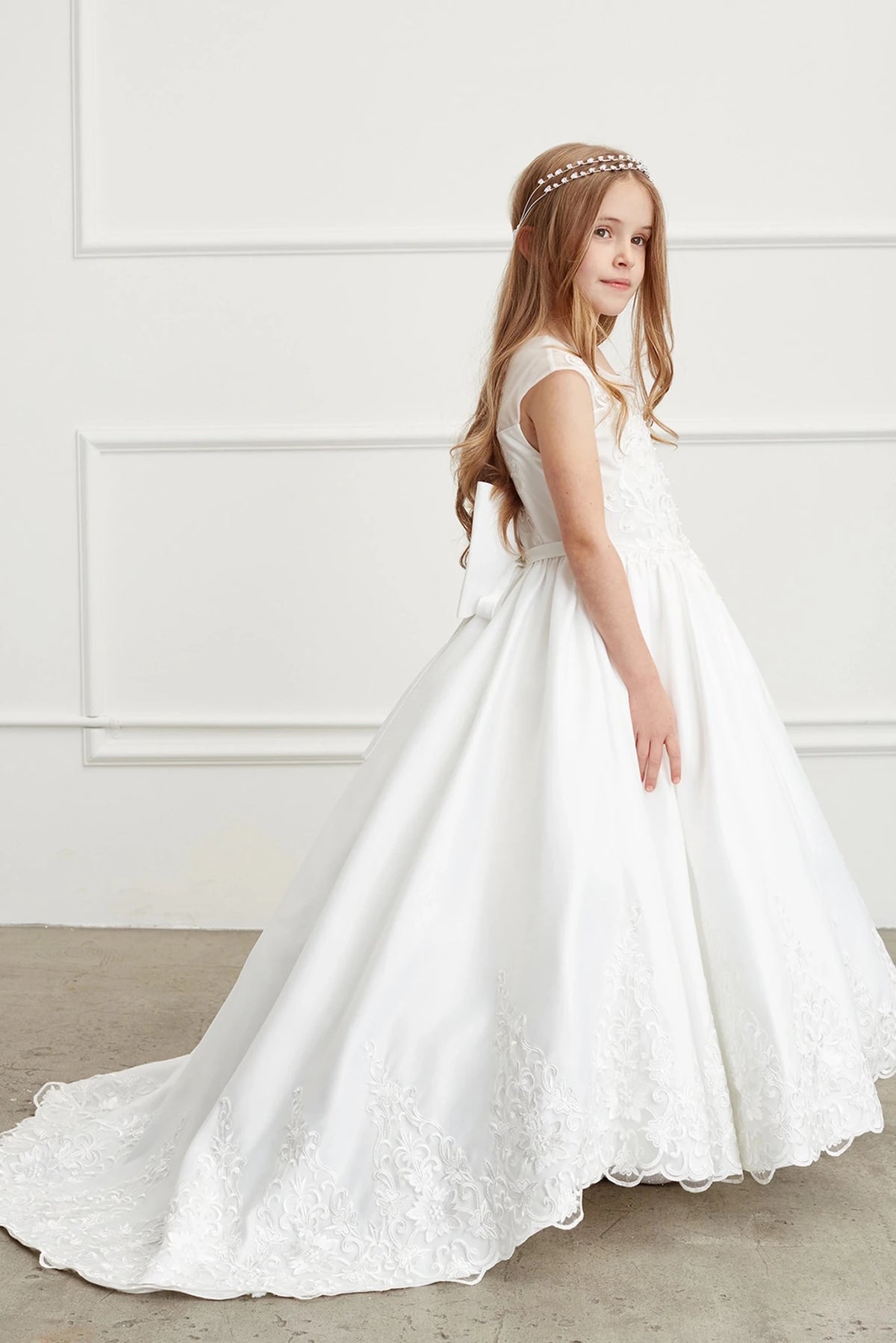 Scalloped lace outlines the off-white flower girl dress's sweeping train.