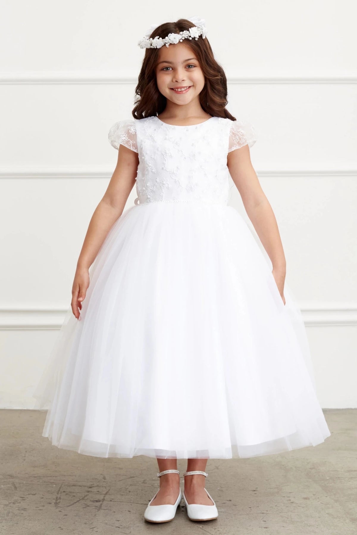Gauzy tulle ends in a fine, sheer hem on the off-white flower girl dress.