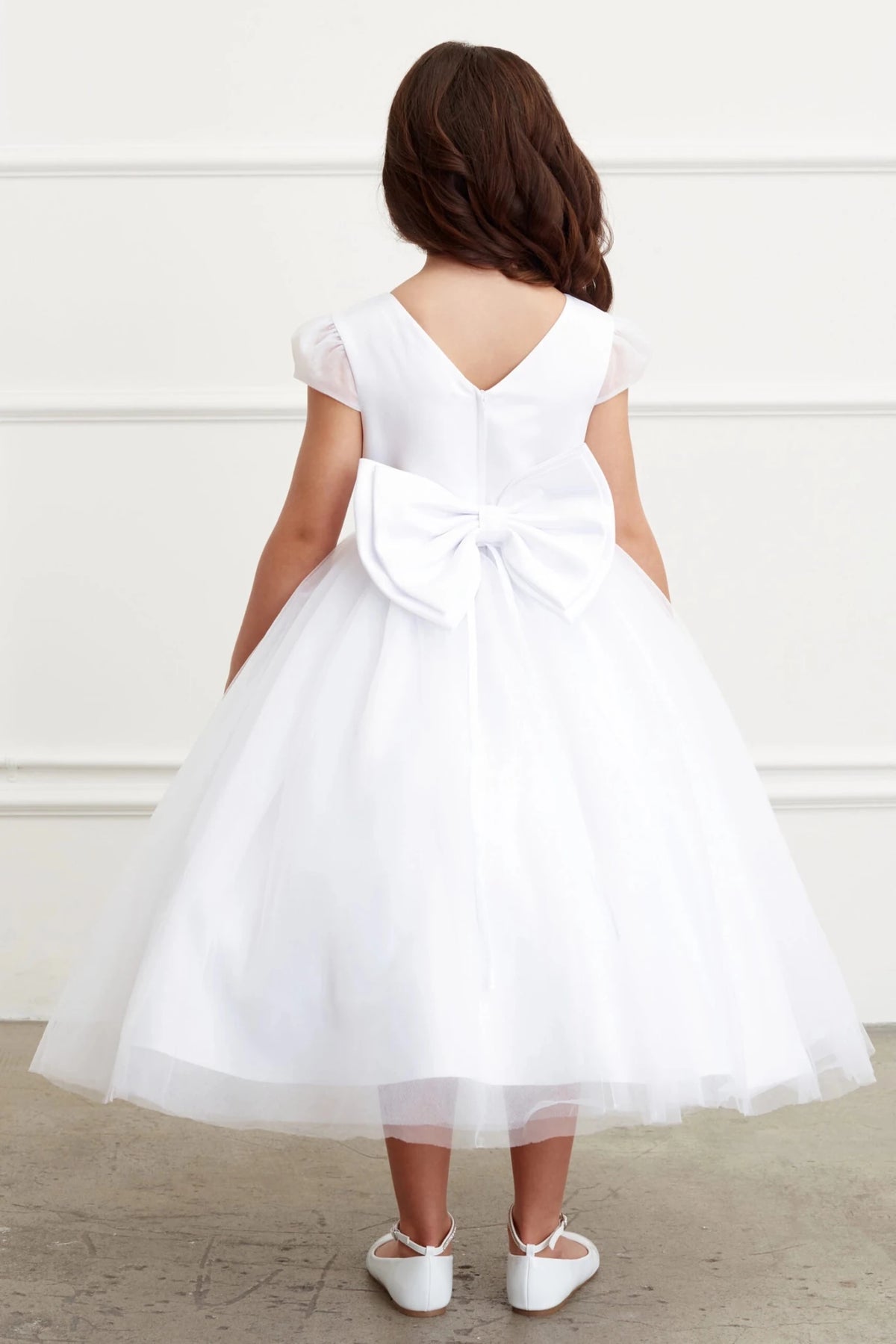 Detailed with deep V back, this white flower girl dress.