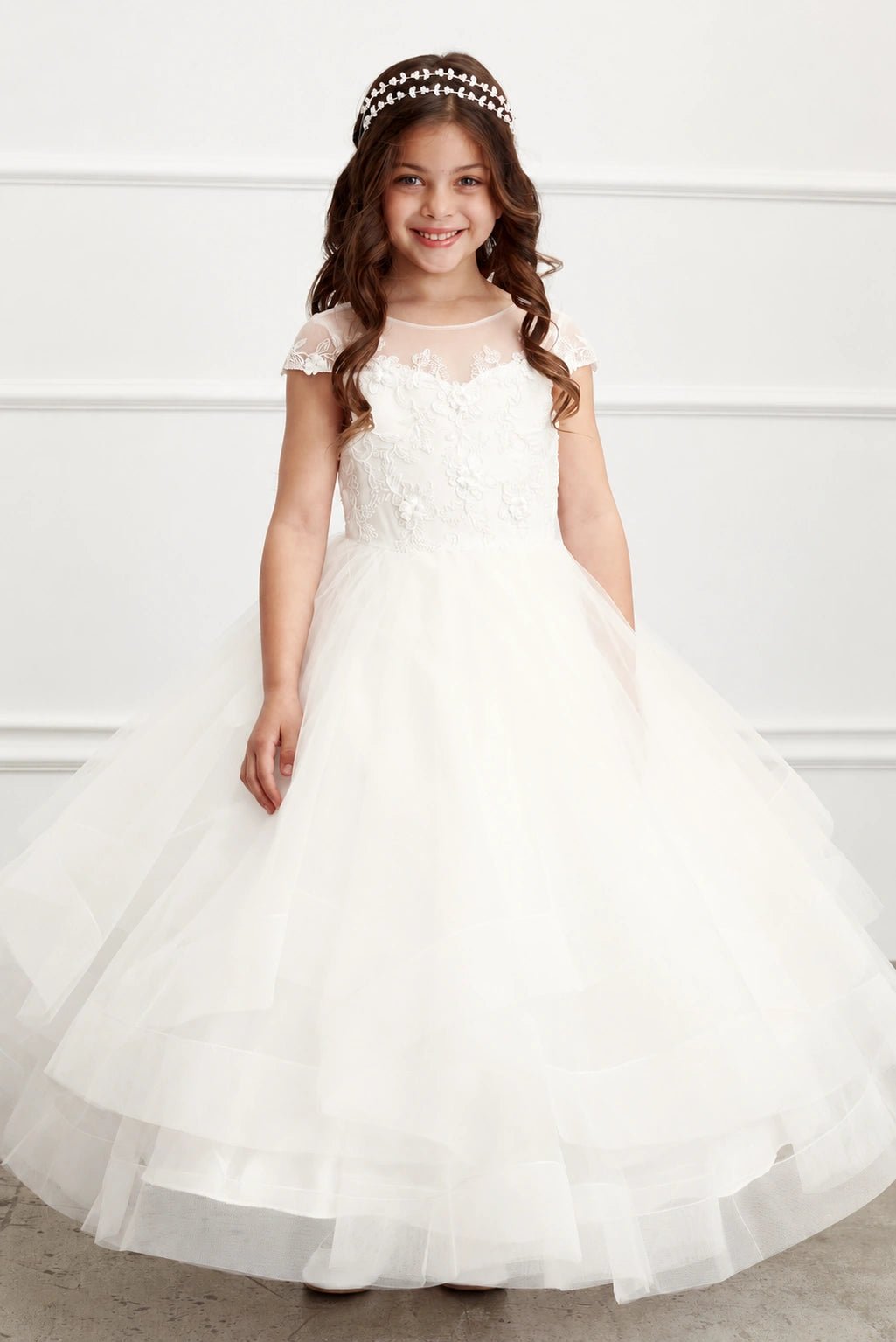 Flowered lace overlays the off-white flower girl dress's sweetheart bodice.