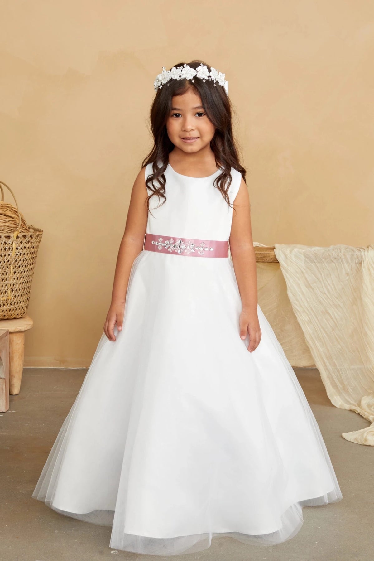 Pink sash with floral sparkle on an off-white flower girl dress.