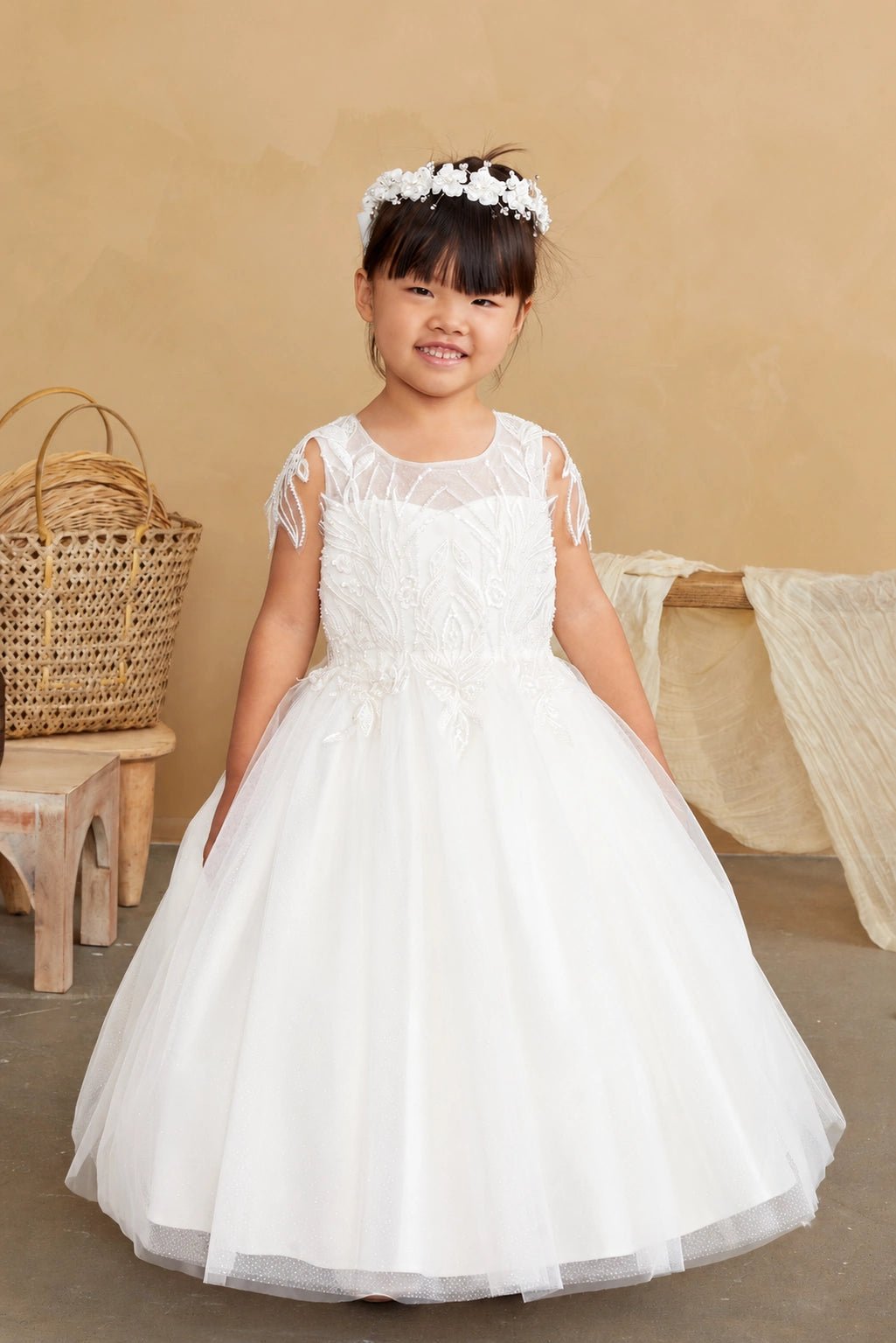 Beaded leaf sleeves accent the off-white flower girl dress.
