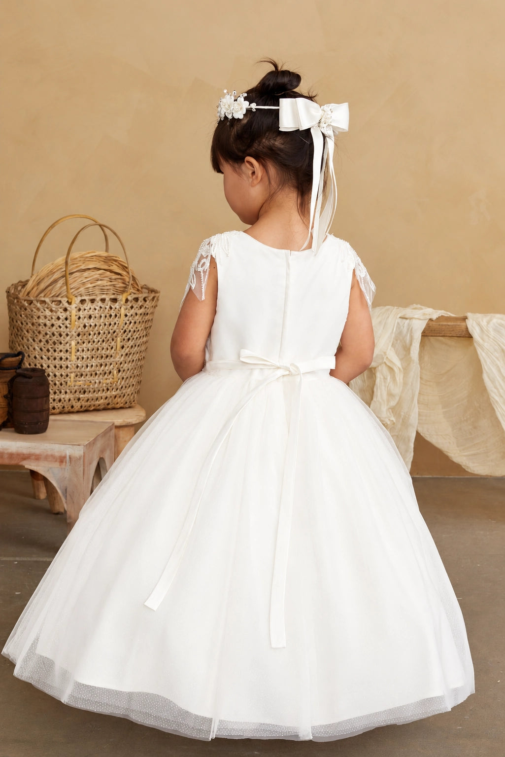 Small satin back bow is visible on the off-white flower girl dress.