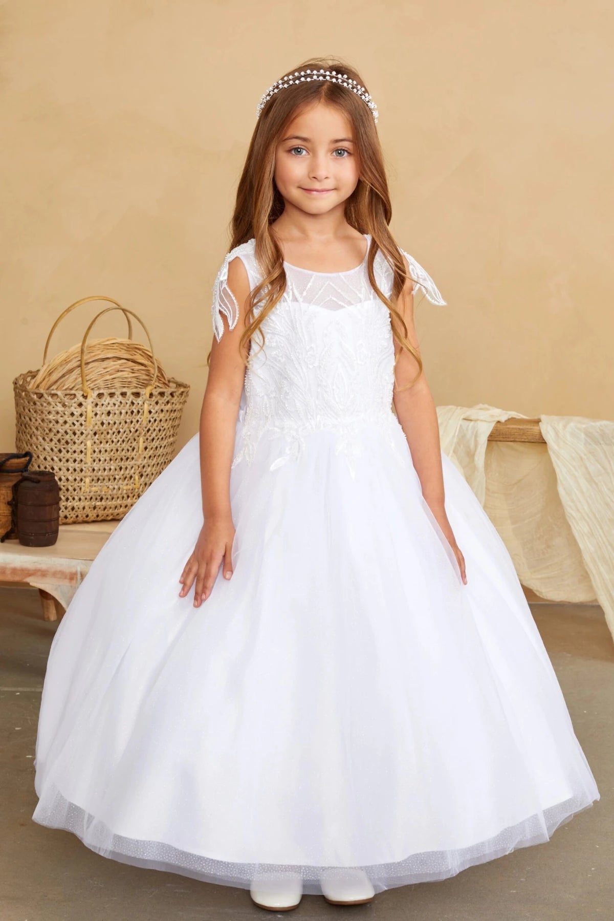 White flower girl dress with leaf-trimmed shoulders.