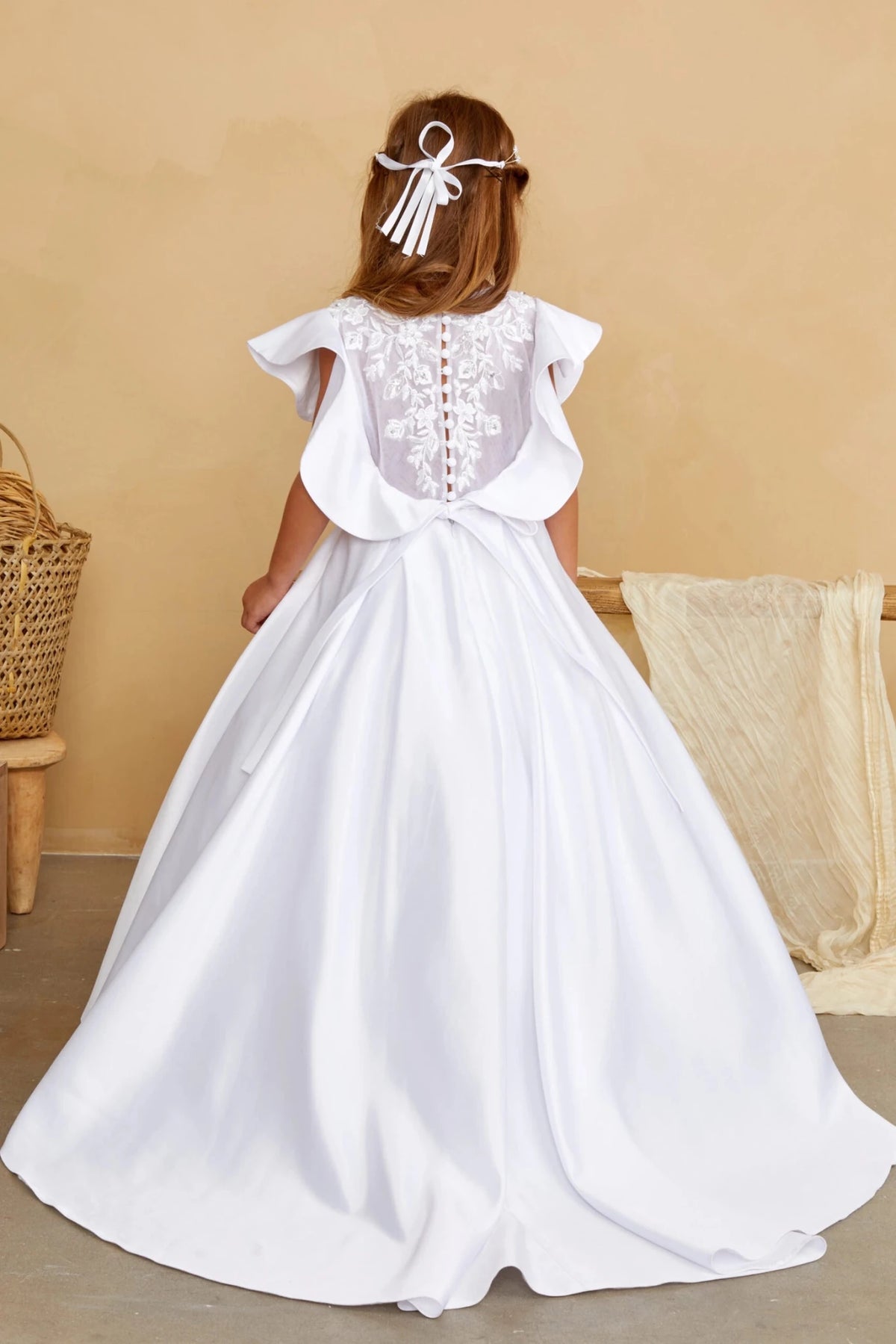 With long satin waist ties, a white flower girl dress.