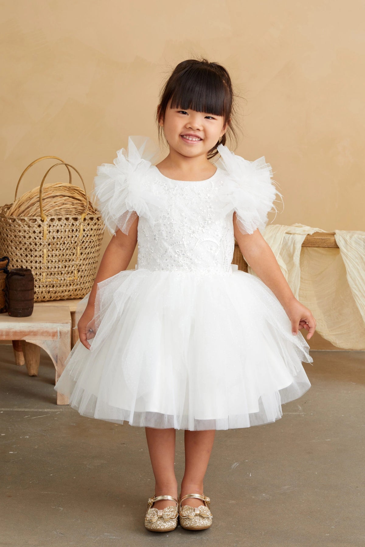 Ivory kids pageant dress featuring feather-trimmed flutter sleeves.