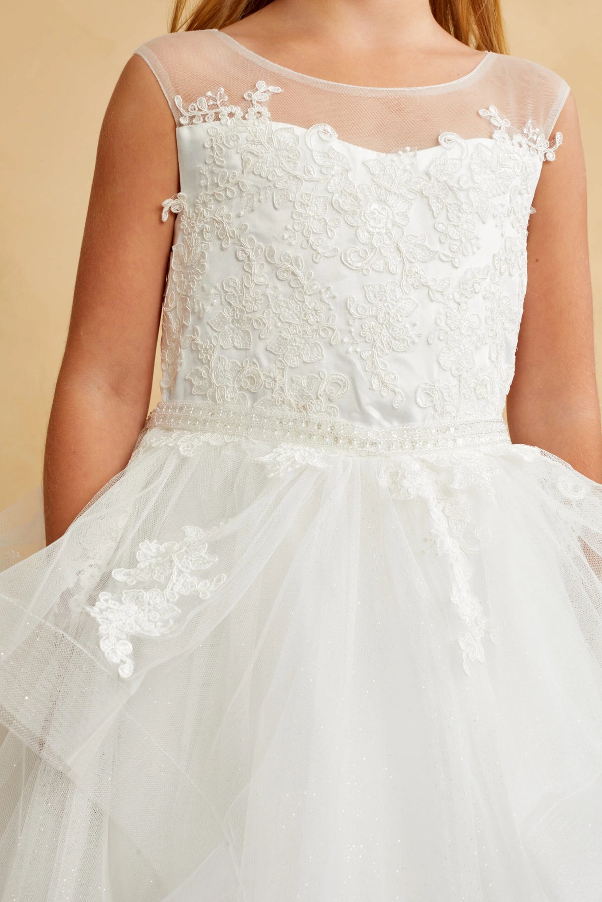 Petal-shaped embroidery edges the off-white flower girl dress's sheer yoke.