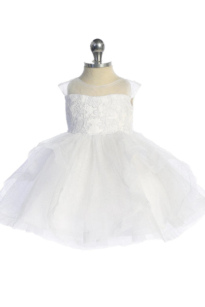 A view of a gathered tulle skirt on the white flower girl dress.