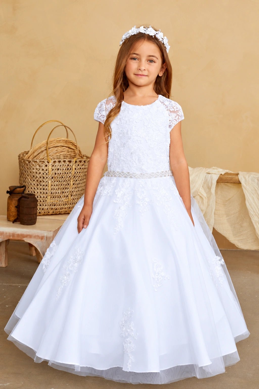 Tapered lace appliques descend onto the white flower girl dress's skirt.