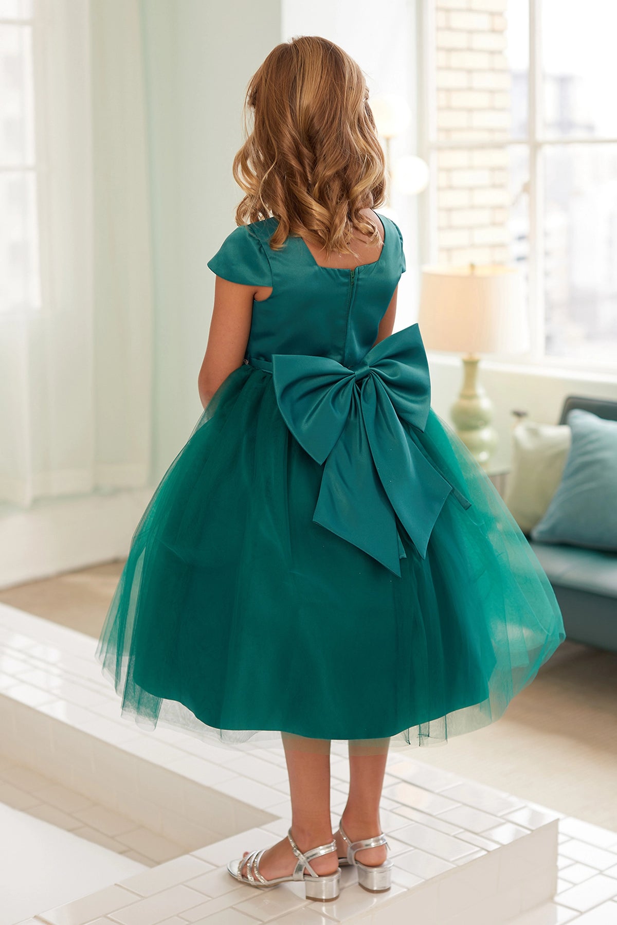 The Emerald kids pageant dress has a large satin bow and square back neckline.