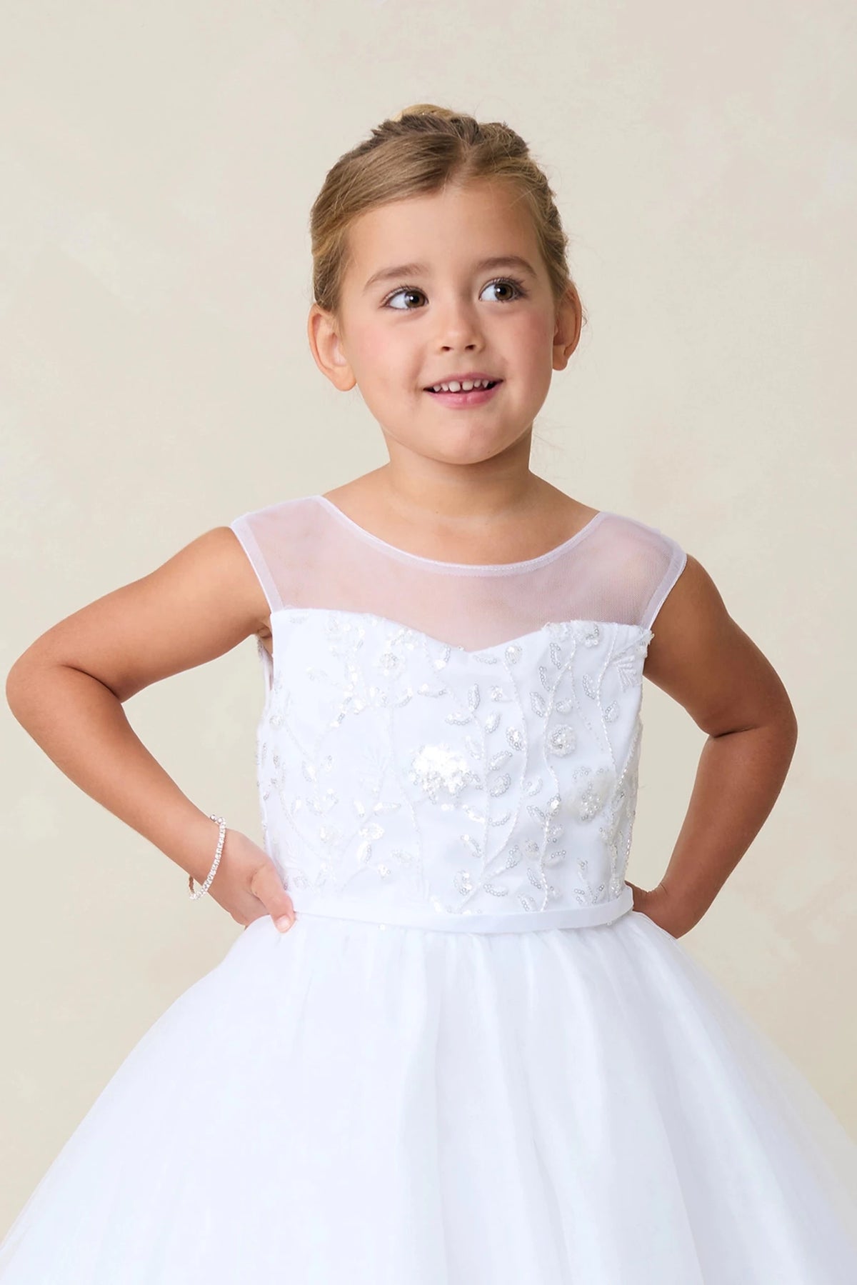 This white flower girl dress displays an embroidered sweetheart bodice.