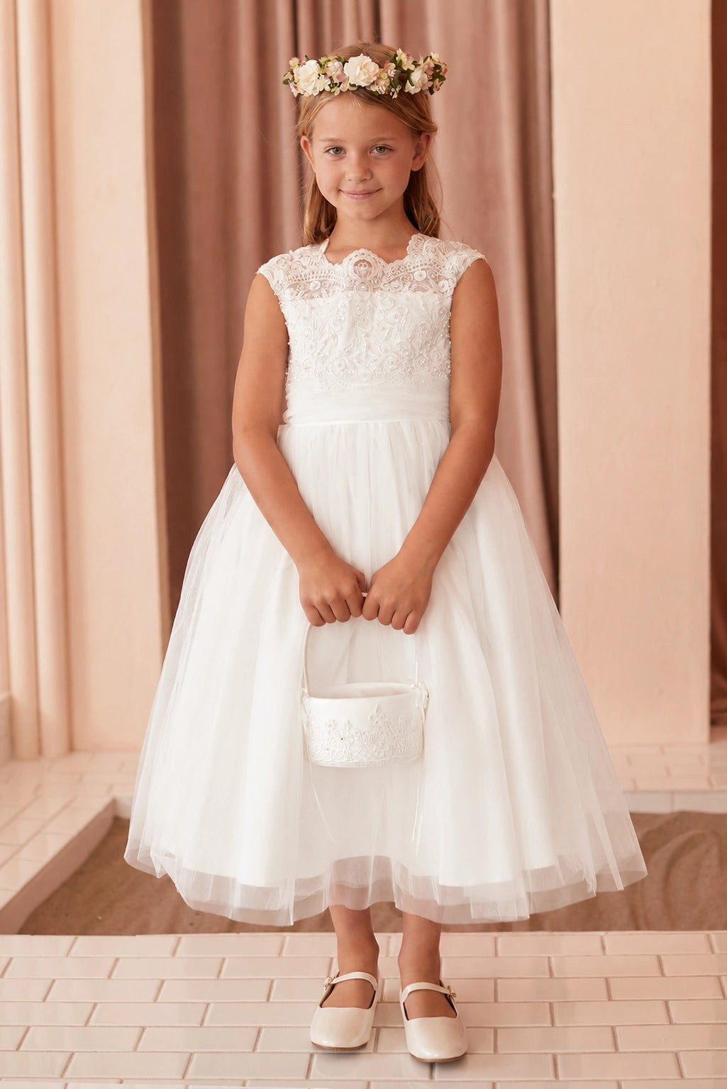 The off-white flower girl dress features a pleated waist sash.