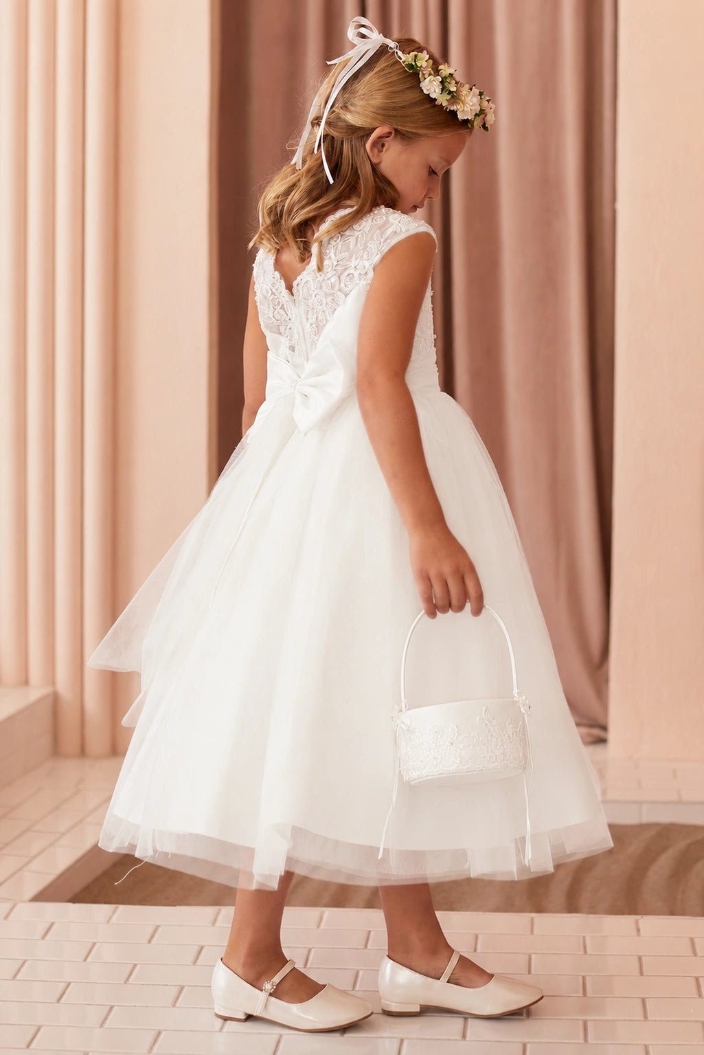 Lace-trimmed cap sleeves on an off-white flower girl dress.